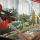 Agent 47 wields a sniper rifle from a balcony above a race track in Miami in Hitman 2.